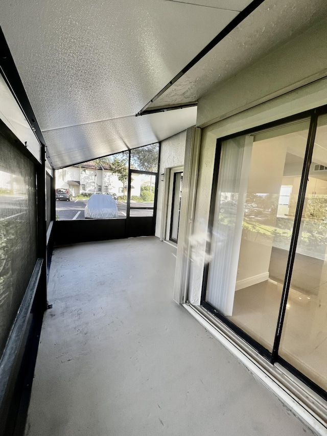 unfurnished sunroom featuring lofted ceiling