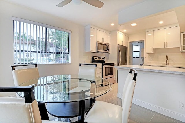 tiled dining space featuring sink and ceiling fan