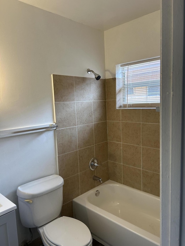 full bathroom with toilet, tiled shower / bath combo, and vanity