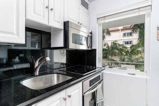 kitchen featuring white cabinets, a wealth of natural light, appliances with stainless steel finishes, and sink