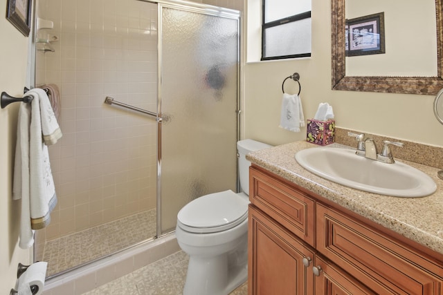 bathroom with toilet, vanity, an enclosed shower, and tile patterned flooring