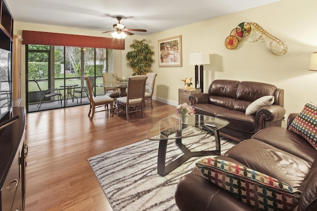 living room with ceiling fan and light hardwood / wood-style flooring