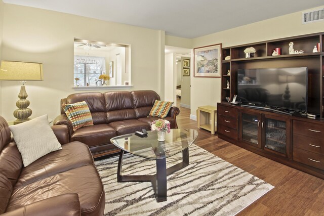 living room featuring ceiling fan and dark hardwood / wood-style flooring