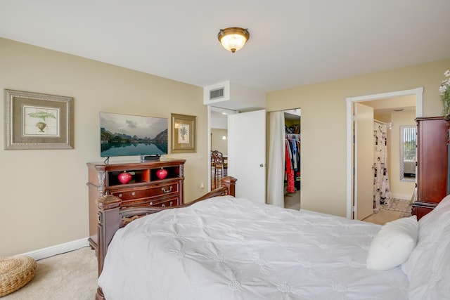 carpeted bedroom featuring ensuite bathroom and a closet