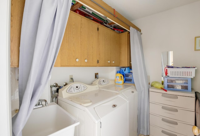 laundry room featuring cabinets, sink, and washing machine and dryer