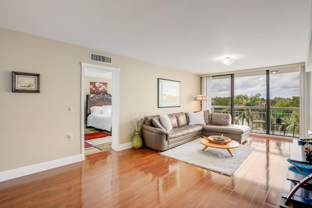 living room featuring wood-type flooring and expansive windows