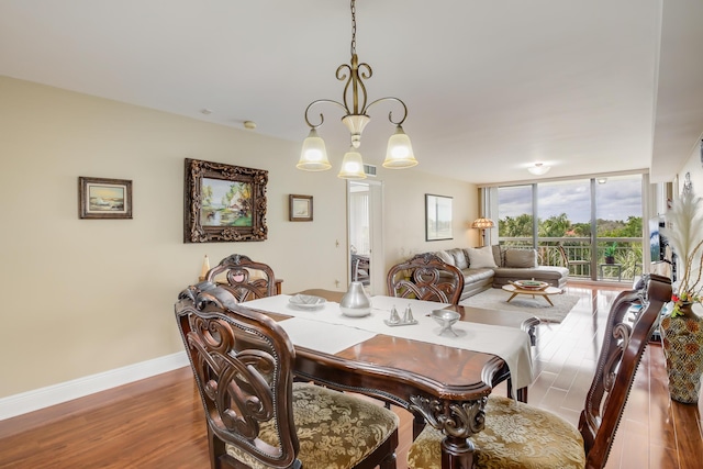 dining room with an inviting chandelier, floor to ceiling windows, and hardwood / wood-style flooring