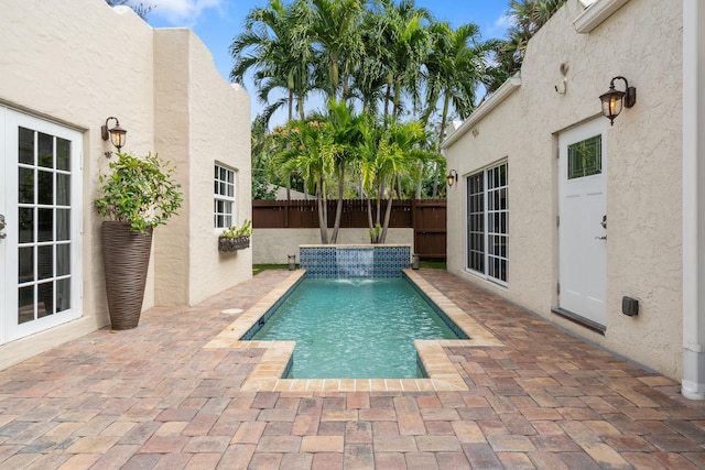 view of swimming pool featuring pool water feature and a patio