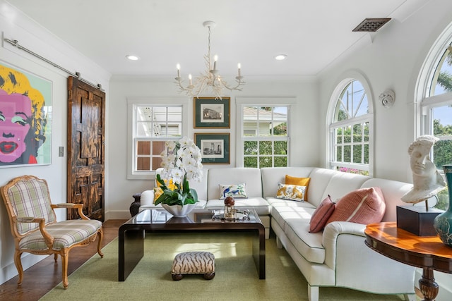 sitting room with hardwood / wood-style floors, crown molding, a chandelier, and a barn door