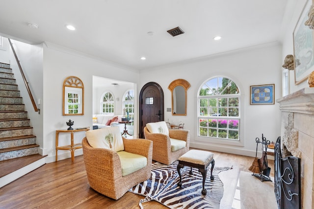 sitting room featuring ornamental molding and light hardwood / wood-style flooring