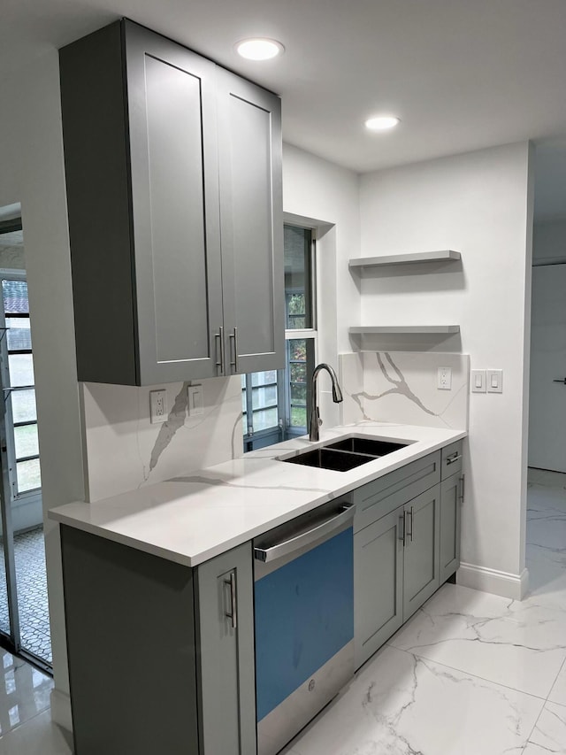 kitchen featuring stainless steel dishwasher, decorative backsplash, sink, and gray cabinetry