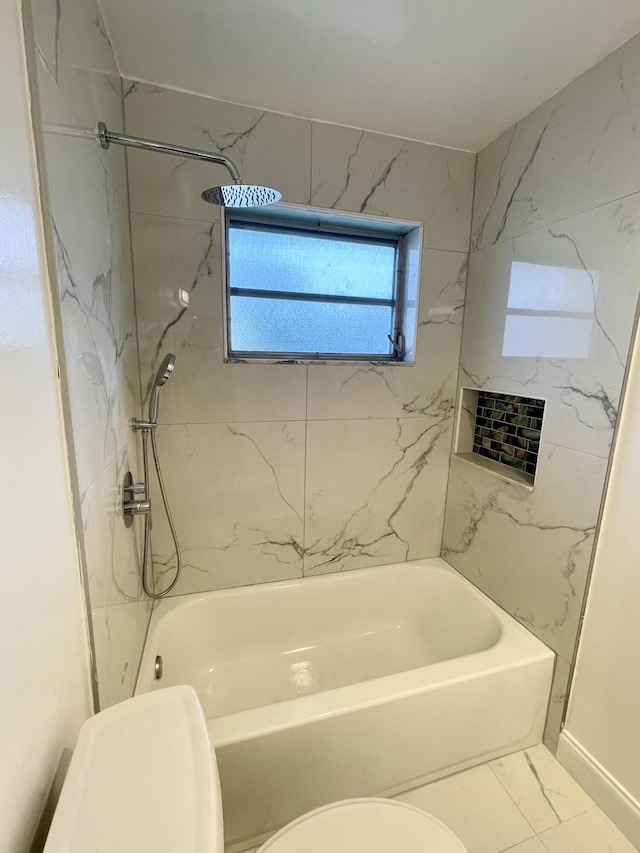 bathroom featuring toilet and tiled shower / bath