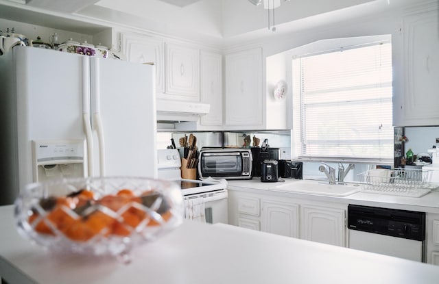 kitchen featuring sink, white cabinets, and white appliances