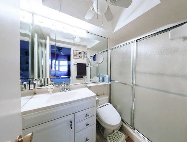 bathroom with toilet, ceiling fan, a shower with shower door, and vanity