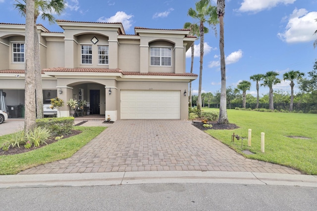 mediterranean / spanish-style home featuring a garage and a front yard