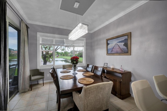 tiled dining space with a water view, crown molding, and a chandelier