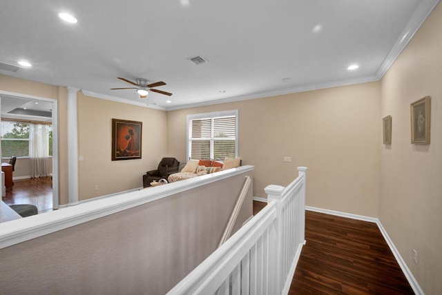 hallway with decorative columns, dark wood-type flooring, and crown molding