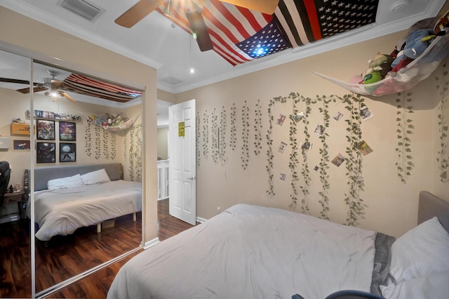 bedroom with a closet, ornamental molding, hardwood / wood-style flooring, and ceiling fan