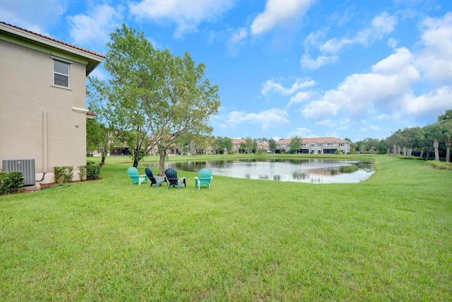 view of yard with a water view and central AC unit