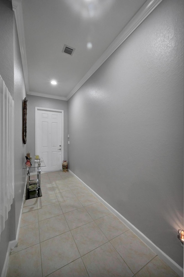 doorway to outside with light tile patterned flooring and ornamental molding