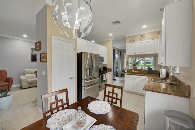 tiled dining space with a chandelier, sink, and ornamental molding