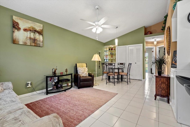 tiled living room with vaulted ceiling, a ceiling fan, a textured ceiling, and baseboards