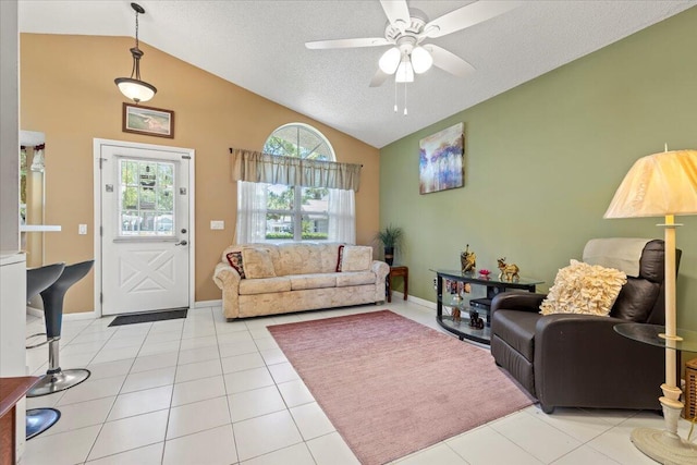 living room with vaulted ceiling, ceiling fan, light tile patterned flooring, and a textured ceiling