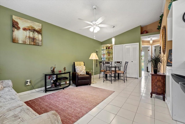 tiled living room with a textured ceiling, ceiling fan, and lofted ceiling