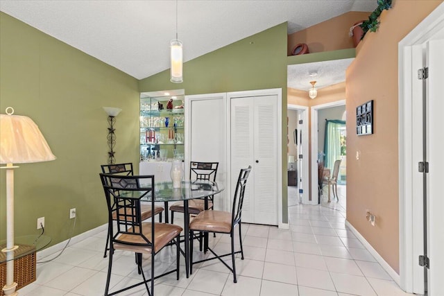 tiled dining space featuring vaulted ceiling