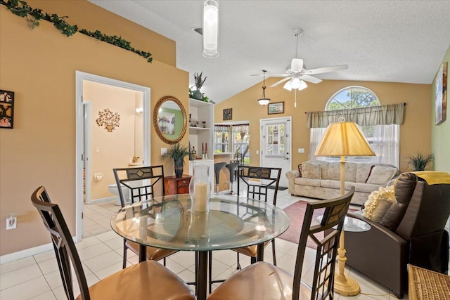 interior space featuring vaulted ceiling, a ceiling fan, baseboards, and light tile patterned floors