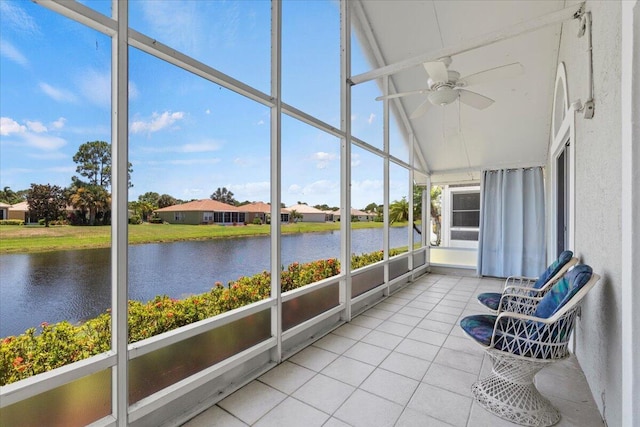 unfurnished sunroom with ceiling fan, lofted ceiling, a water view, and plenty of natural light