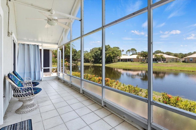 unfurnished sunroom with ceiling fan, a water view, and vaulted ceiling