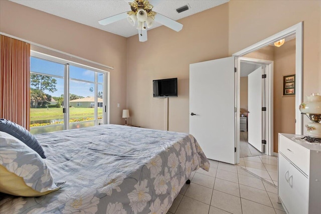 bedroom with ceiling fan, light tile patterned floors, and access to outside