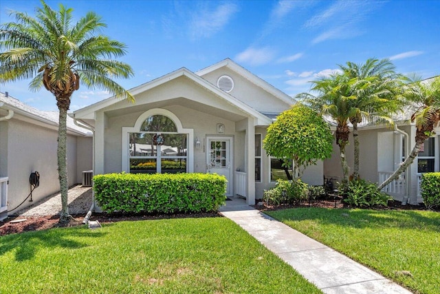 view of front of home featuring a front yard, central air condition unit, and stucco siding
