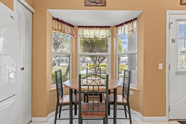 dining room featuring a textured ceiling and light tile patterned flooring