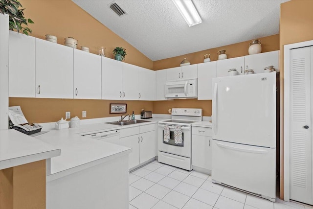 kitchen with vaulted ceiling, a sink, a textured ceiling, white appliances, and a peninsula