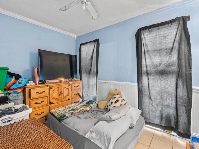 tiled bedroom featuring ceiling fan and crown molding