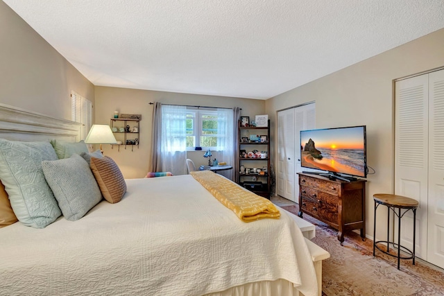 bedroom with multiple closets and a textured ceiling