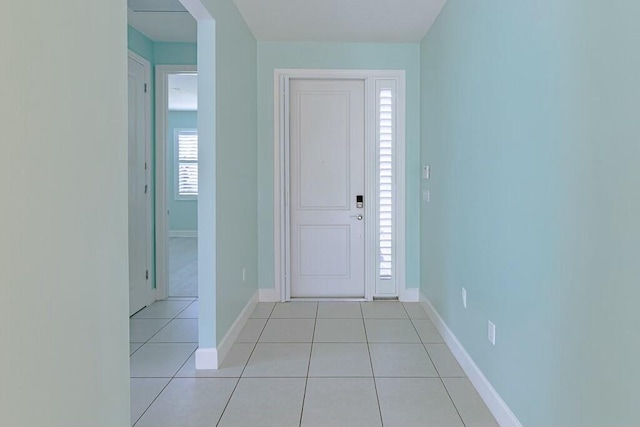 foyer entrance featuring light tile patterned flooring and baseboards