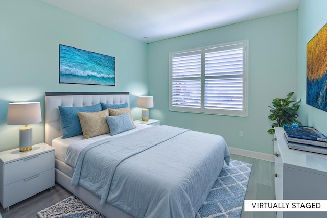 bedroom featuring baseboards and wood finished floors