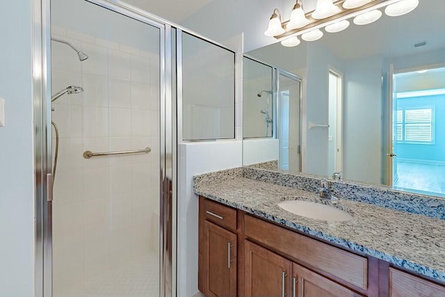 full bathroom with visible vents, a shower stall, and vanity