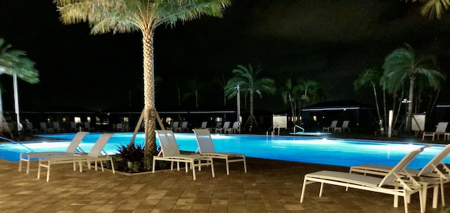 pool at night with a patio area