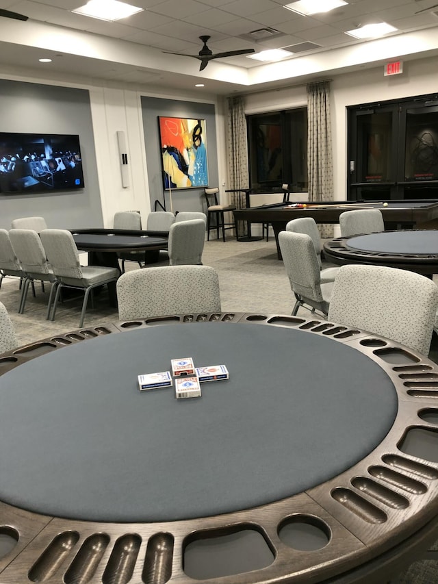 rec room featuring carpet floors, a drop ceiling, and visible vents