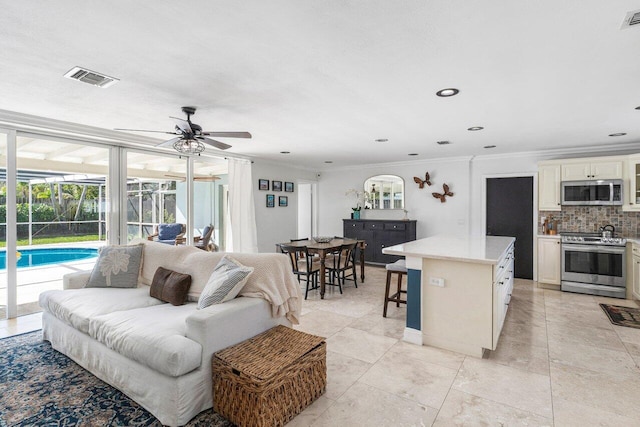 living room featuring ceiling fan and crown molding