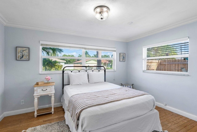 bedroom with ornamental molding and hardwood / wood-style flooring