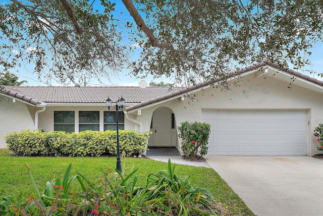 ranch-style home with a front lawn and a garage