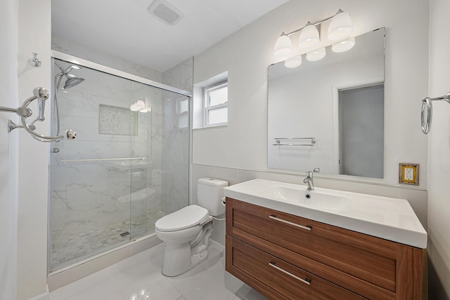 bathroom with toilet, vanity, tile patterned flooring, tile walls, and a shower with shower door