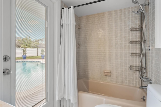 bathroom featuring toilet and shower / bath combo with shower curtain