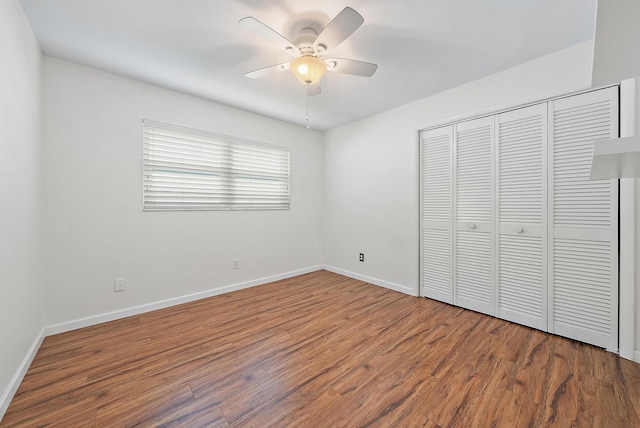 unfurnished bedroom featuring ceiling fan, a closet, and hardwood / wood-style flooring