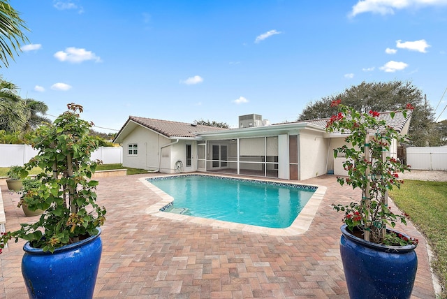 view of swimming pool with a patio and a sunroom